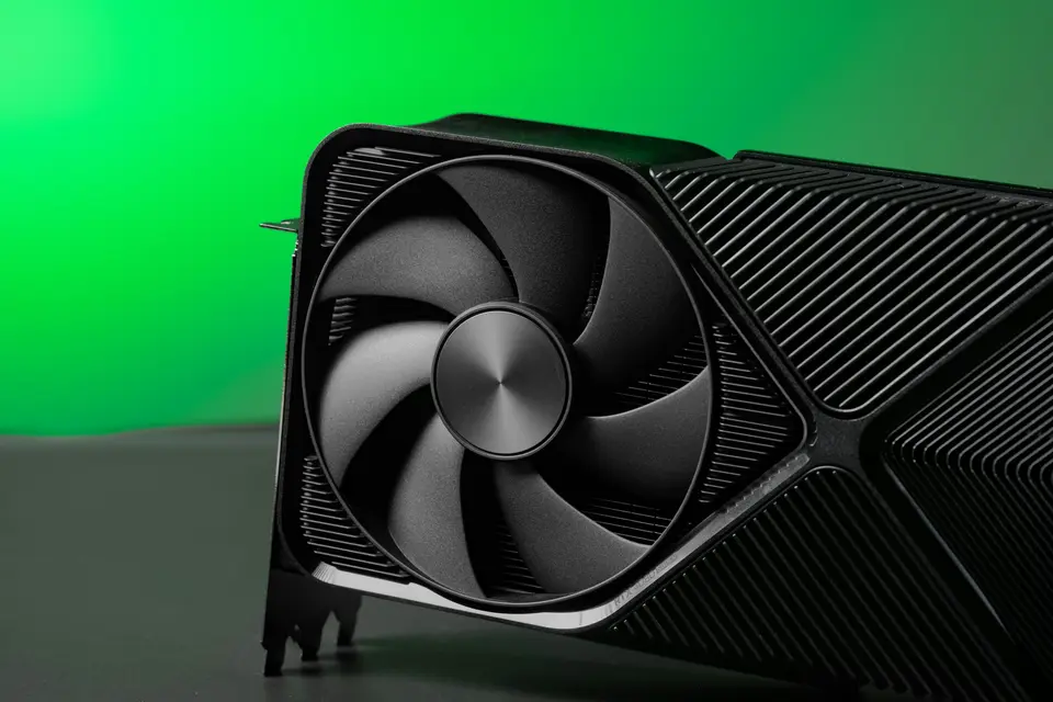 A graphics card with a large fan against a green backdrop